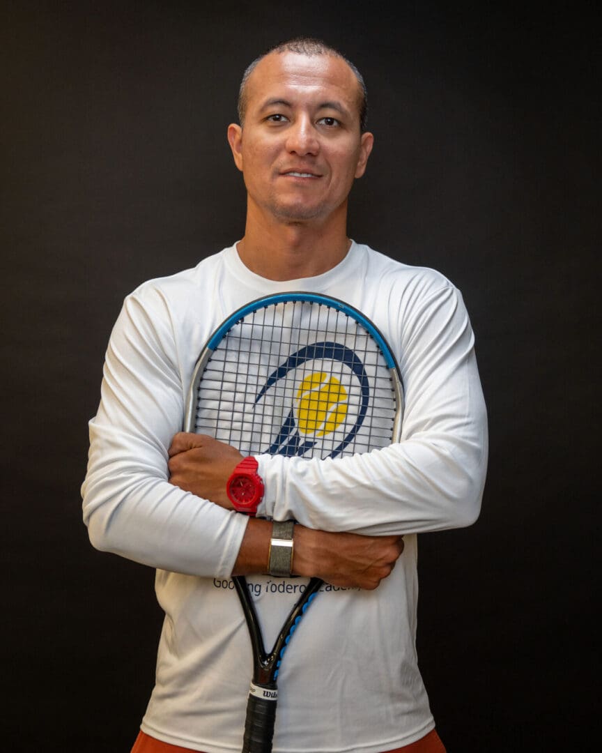 Man holding tennis racket against black background